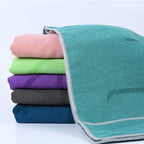 Stack of folded microfiber pilates towels in teal, pink, green, purple, grey, and blue